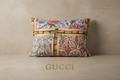 A rectangular patchwork fabric bag with a multicolor print featuring pink, green, red, and beige patterns, including bamboo motifs and floral designs, resting on a light wood surface.
